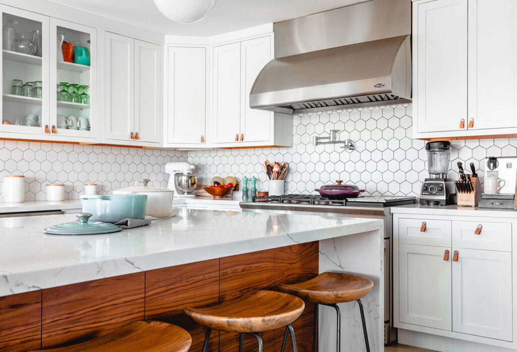 Dream kitchen with white tiles and white cabinets. Quartz countertop with marble veins